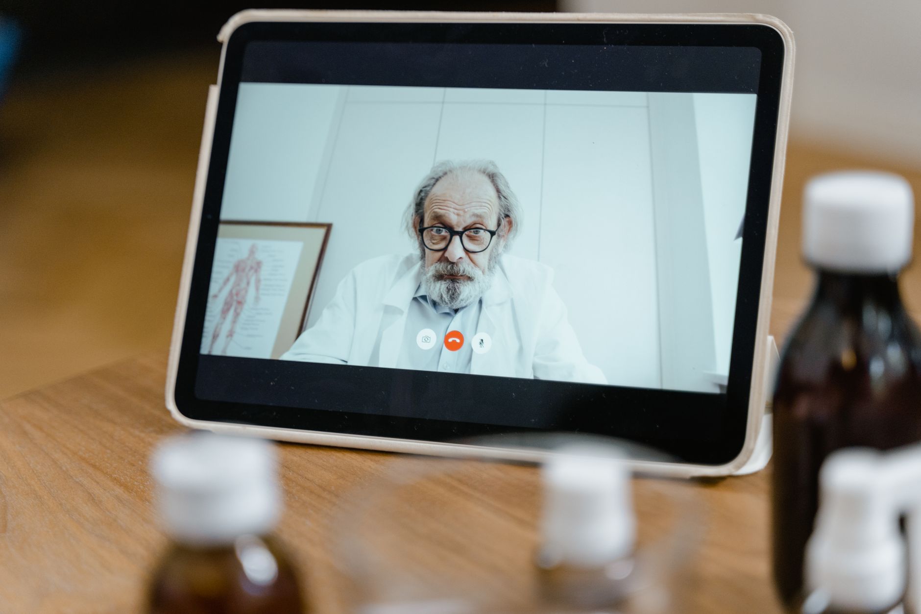 A clinic coordinator conducting a video consultation aftercare check-in with a UK patient recovering at home