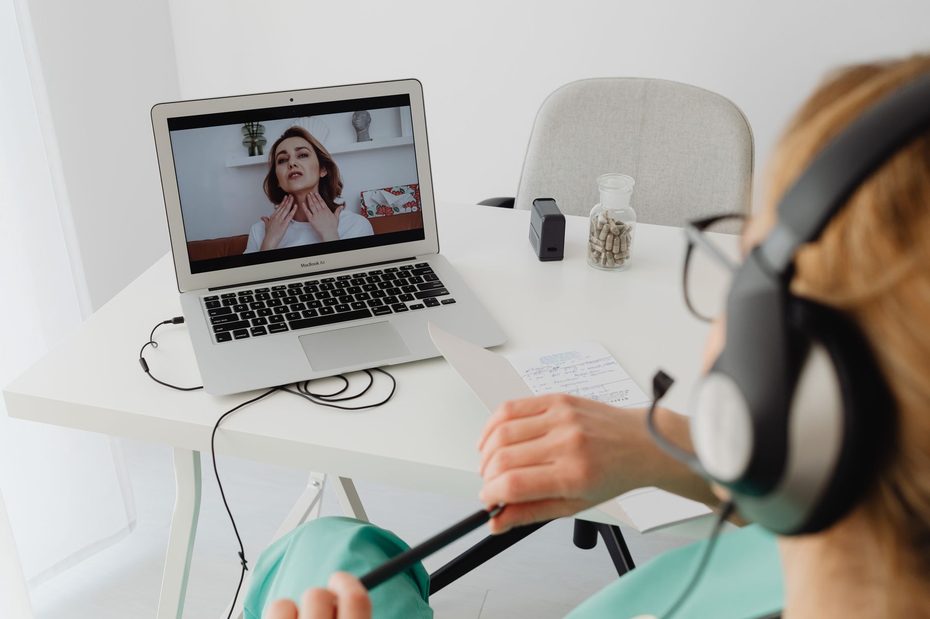 A clinic coordinator conducting a remote video consultation with a UK patient recovering at home after treatment abroad