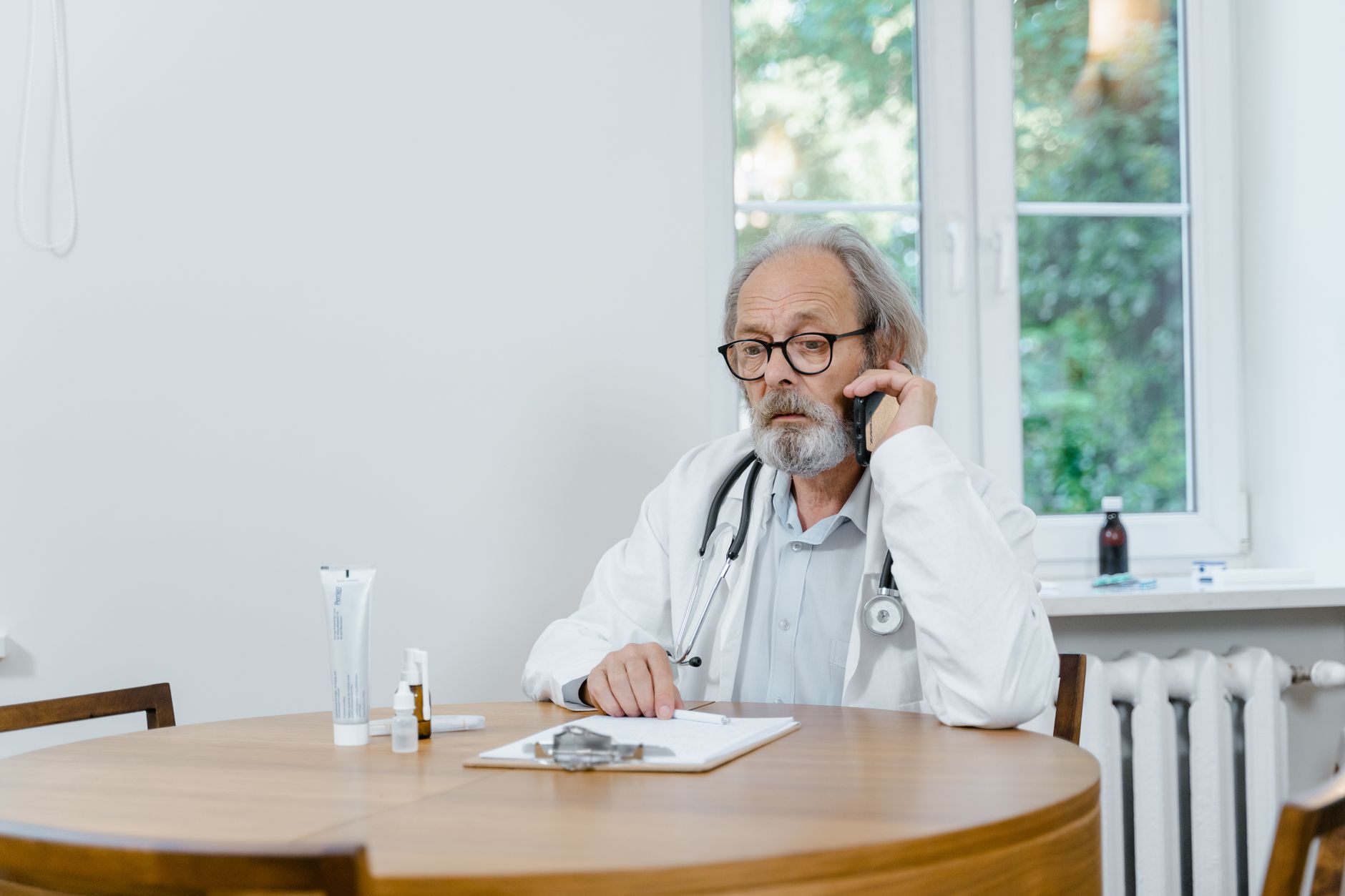 A clinic consultant responding promptly to a UK patient enquiry on a laptop and smartphone