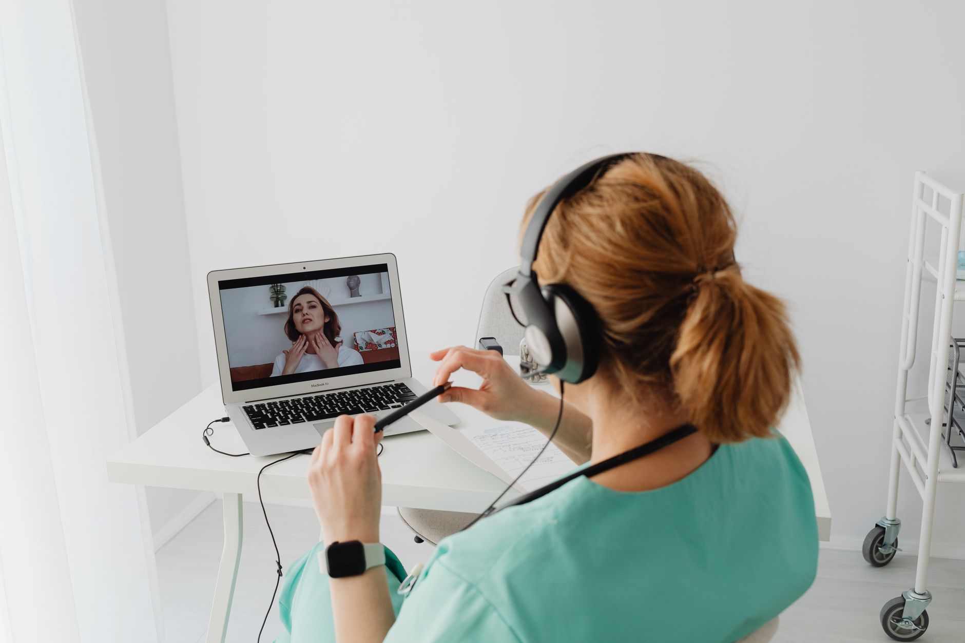 A clinic doctor conducting a remote video consultation with a UK patient recovering at home after a medical procedure abroad