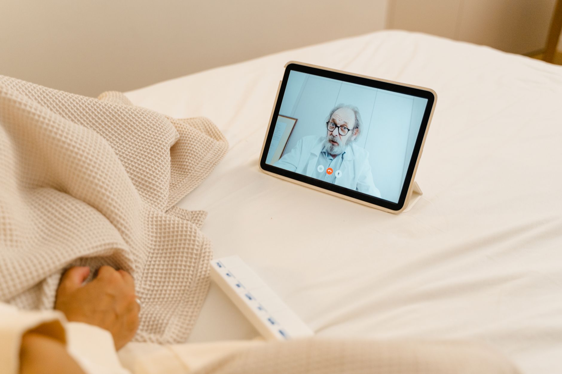A patient at home having a remote video consultation with their overseas clinic doctor as part of a structured aftercare pathway