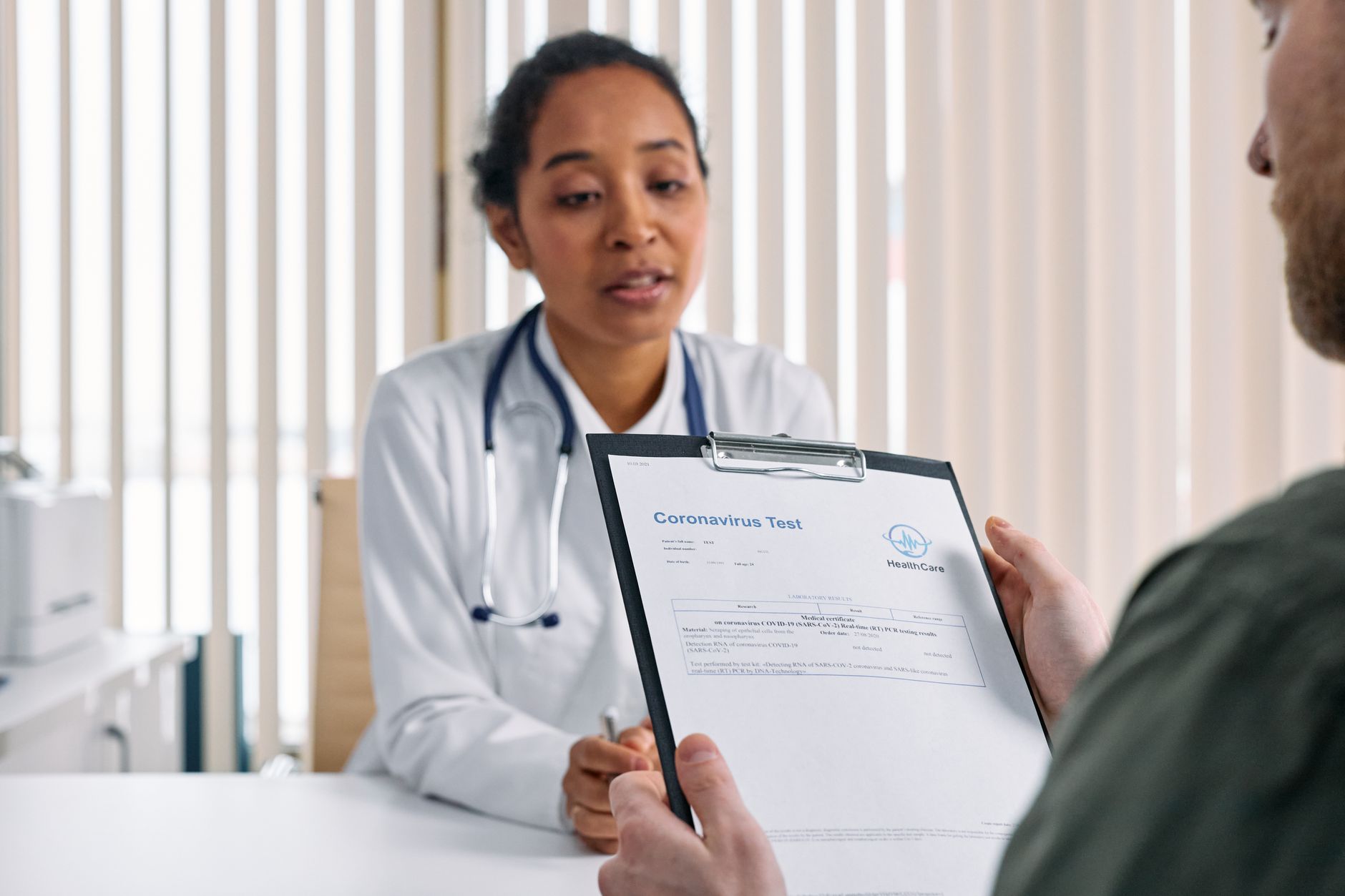 A clinic consultant reviewing treatment options with an international patient in a professional, modern medical setting